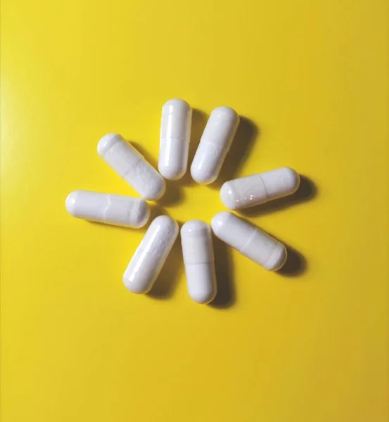 White Capsules Yellow Background — Stock Photo, Image
