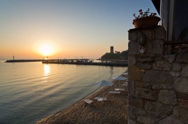 Yunanistan 'da küçük balıkçı limanı yakınlarındaki sahilde gün doğumu