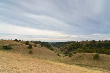 Sırbistan 'ın kuzeyinde, küçük tepeler arasında kara bulutların altında bir vadi
