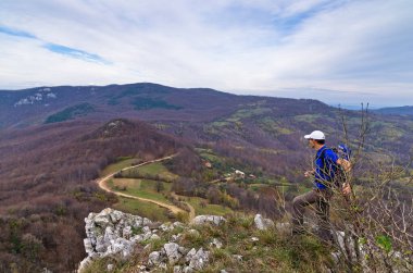 Aşağıdaki virajlı dağ yolunu izleyen bir yürüyüşçü, Homolje dağları, doğu Sırbistan