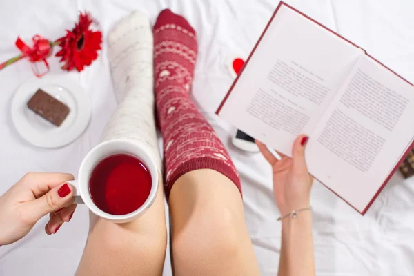 Mujer tomando una taza de té en la cama — Foto de Stock