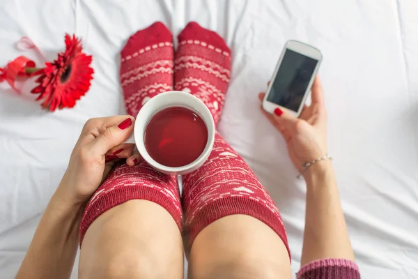 Mujer tomando una taza de té y mensajes de texto —  Fotos de Stock