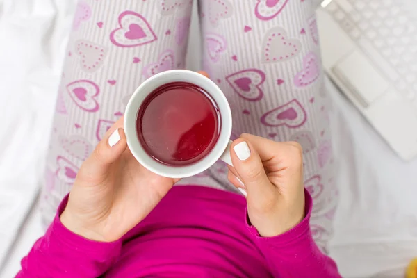 Mujer tomando una taza de té en la cama —  Fotos de Stock
