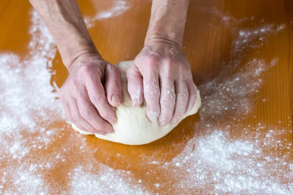 Mãos de um padeiro masculino que faz pão — Fotografia de Stock