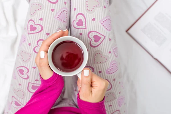 Mulher tomando uma xícara de chá na cama — Fotografia de Stock