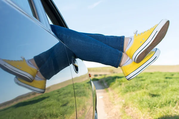 Frauenbeine aus dem Autofenster — Stockfoto