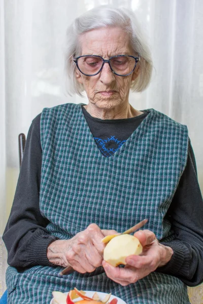 Vieja abuela cortando y pelando una manzana —  Fotos de Stock