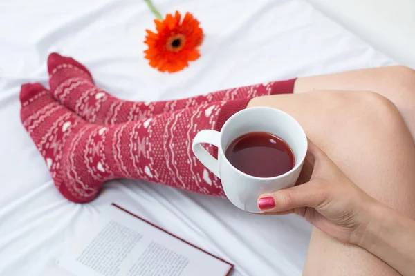 Mujer con taza de té en la cama —  Fotos de Stock
