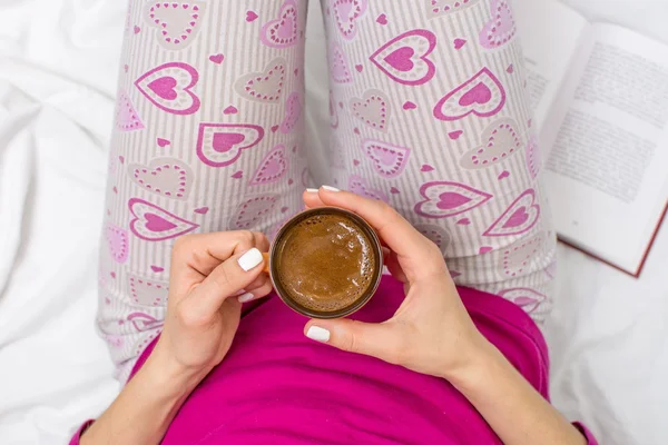 Mulher tomando uma xícara de café na cama — Fotografia de Stock