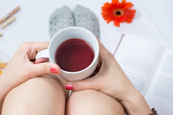 Mulher com xícara de chá na cama — Fotografia de Stock