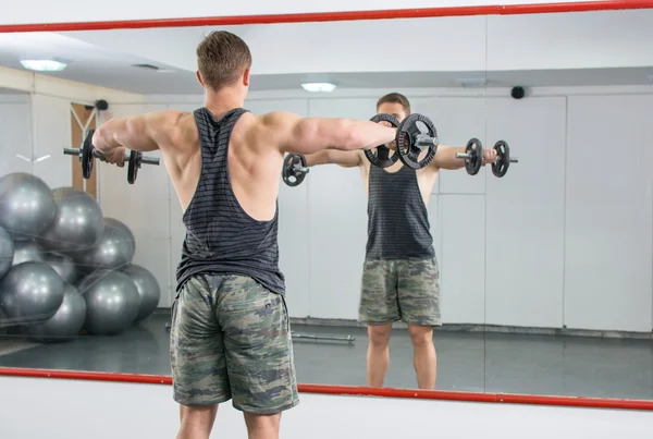 Man performing shoulder workout at the gym — Stock Photo, Image