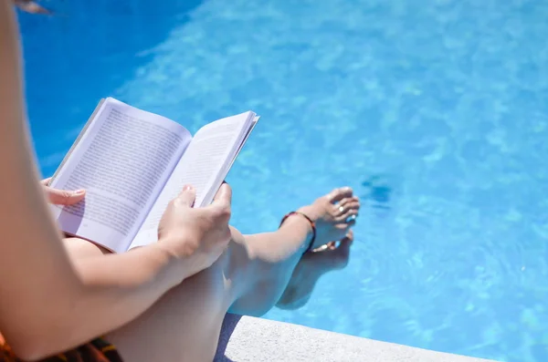 Девушка читает у бассейна — стоковое фото