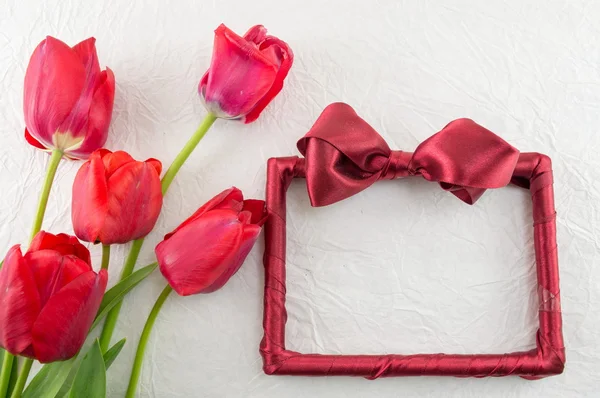 Tulipanes rojos sobre un tejido de seda — Foto de Stock