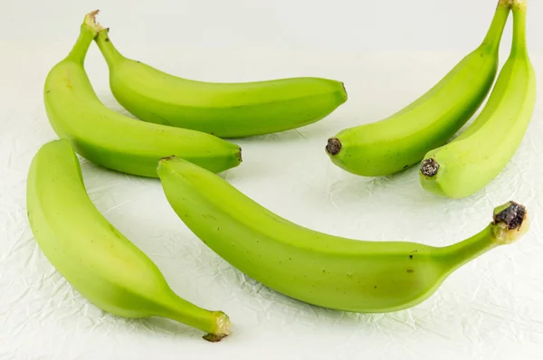 Banane verdi su tessuto bianco — Foto Stock