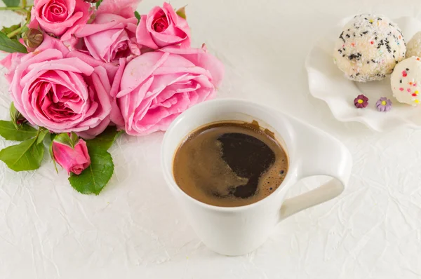 Rosa Rosen und eine Kaffeetasse — Stockfoto