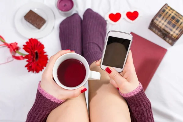 Mujer tomando una taza de té y mensajes de texto —  Fotos de Stock