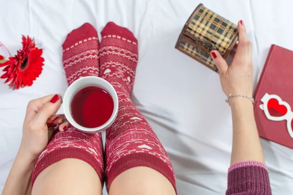 Mujer tomando una taza de té en la cama —  Fotos de Stock