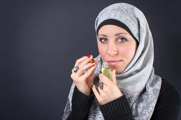 Muslim woman in hijab with a perfume — Stock Photo, Image