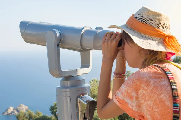 Kvinna som tittar igenom kikare på horisonten. — Stockfoto