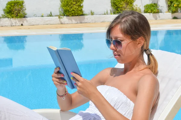 Kadın havuzun yanında bir kitap okuma — Stok fotoğraf