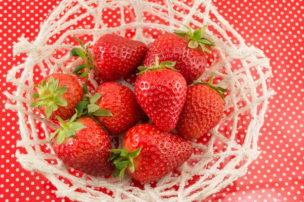 Fresh strawberries on a red dotted background — Stock Photo, Image