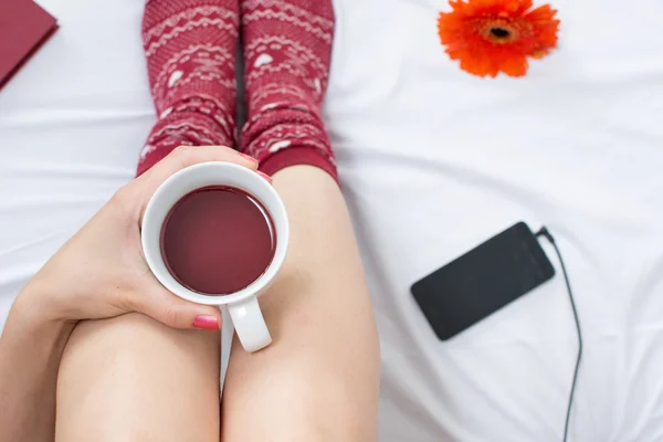 Mujer con taza de té en la cama —  Fotos de Stock