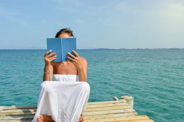 Kız bir iskelede oturup kitap okumak — Stok fotoğraf