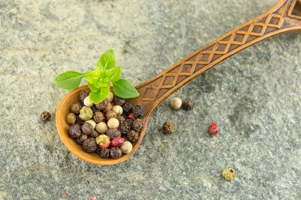 Pimienta granos de especias en una cuchara de madera — Foto de Stock