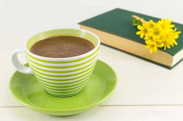 Чашка кави зі свіжими квітами та книгою — стокове фото