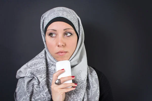 Muslimische Frau im Hidschab hält Handy in der Hand — Stockfoto