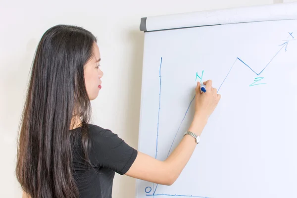 Young woman writing on a flipchart — Stock Photo, Image