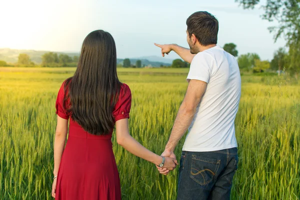麦畑で手を繋いでいるカップル — ストック写真