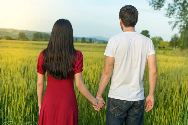 麦畑で手を繋いでいるカップル — ストック写真
