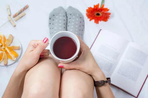 Mujer con taza de té en la cama —  Fotos de Stock