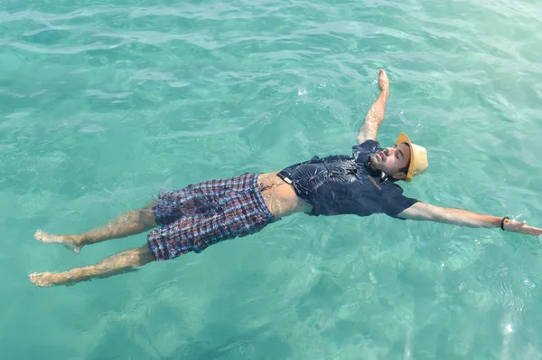 Mies kelluu vedessä. Kesän rentoutuminen — kuvapankkivalokuva