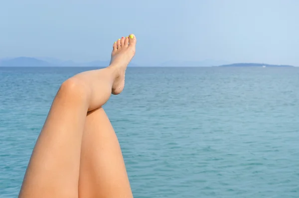 Žena nohy pobřeží těší slunečný den — Stock fotografie