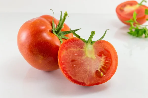 Pomodoro affettato su una tavola di legno bianca — Foto Stock