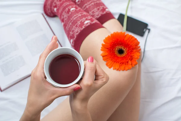 Donna che tiene una tazza di tè a letto — Foto Stock
