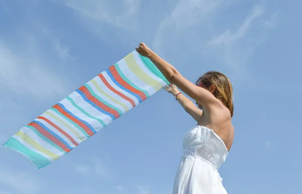 Girl waving a colorful scarf on seaside — Stock Photo, Image