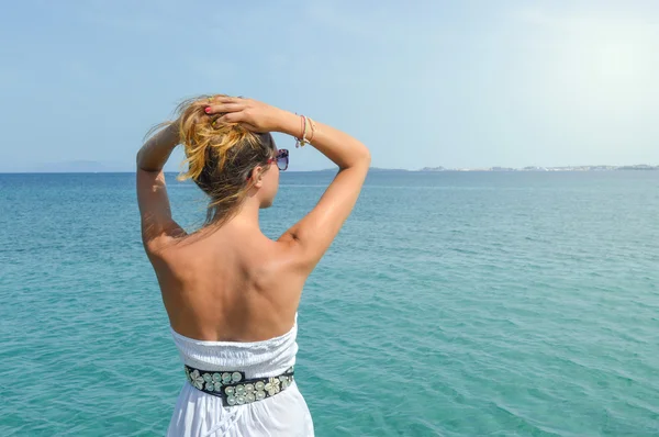 Femme bronzée en robe face à la mer. Vacances Suumer — Photo