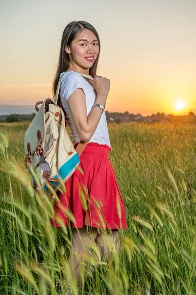 Mujer de pie en un campo de trigo al atardecer —  Fotos de Stock