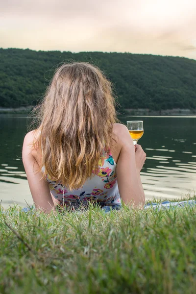 Mujer tomando una copa de vino junto al lago —  Fotos de Stock