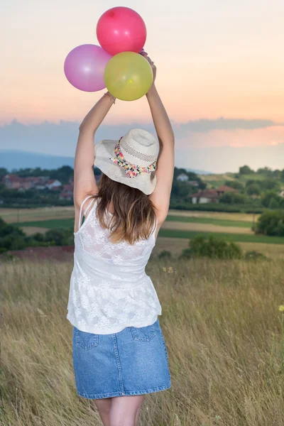 夕日を見て風船を保持している若い女性 — ストック写真