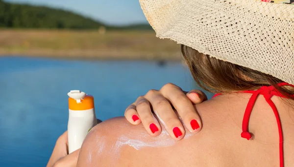 Junge Frau legt sich in den Sommerferien mit Sonnencreme ein — Stockfoto