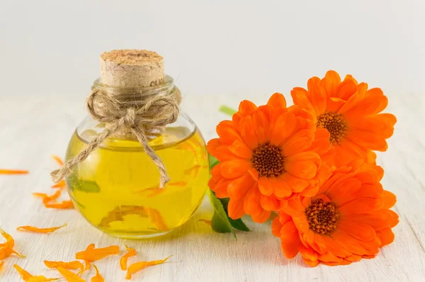 Olej z nagietka z bukietem świeżych kwiatów — Zdjęcie stockowe