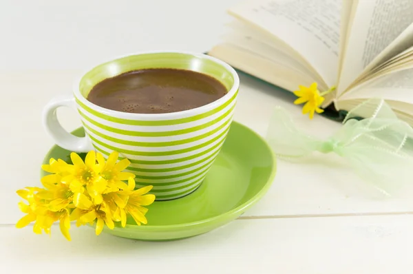 Чашка кави зі свіжими квітами та книгою — стокове фото