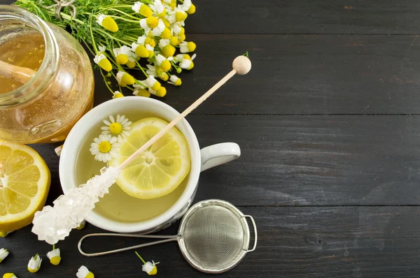 Chá de camomila com fatia de limão e flores — Fotografia de Stock