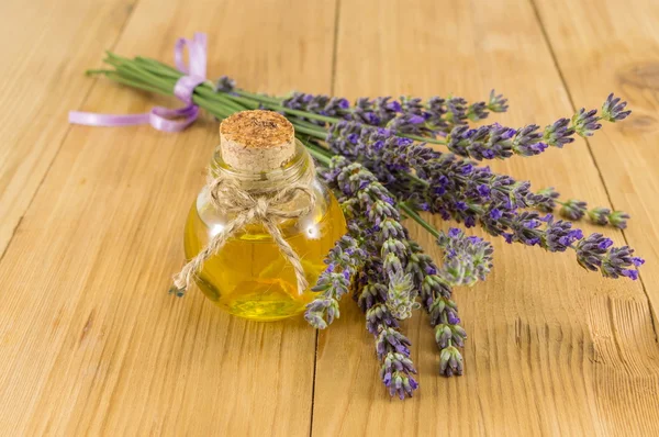 Olio di lavanda con rami di fiori freschi — Foto Stock