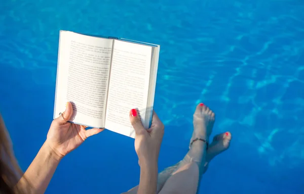 Девушка читает у бассейна — стоковое фото
