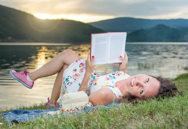 Kadın göl kenarında bir kitap okuma. Solo gevşeme — Stok fotoğraf